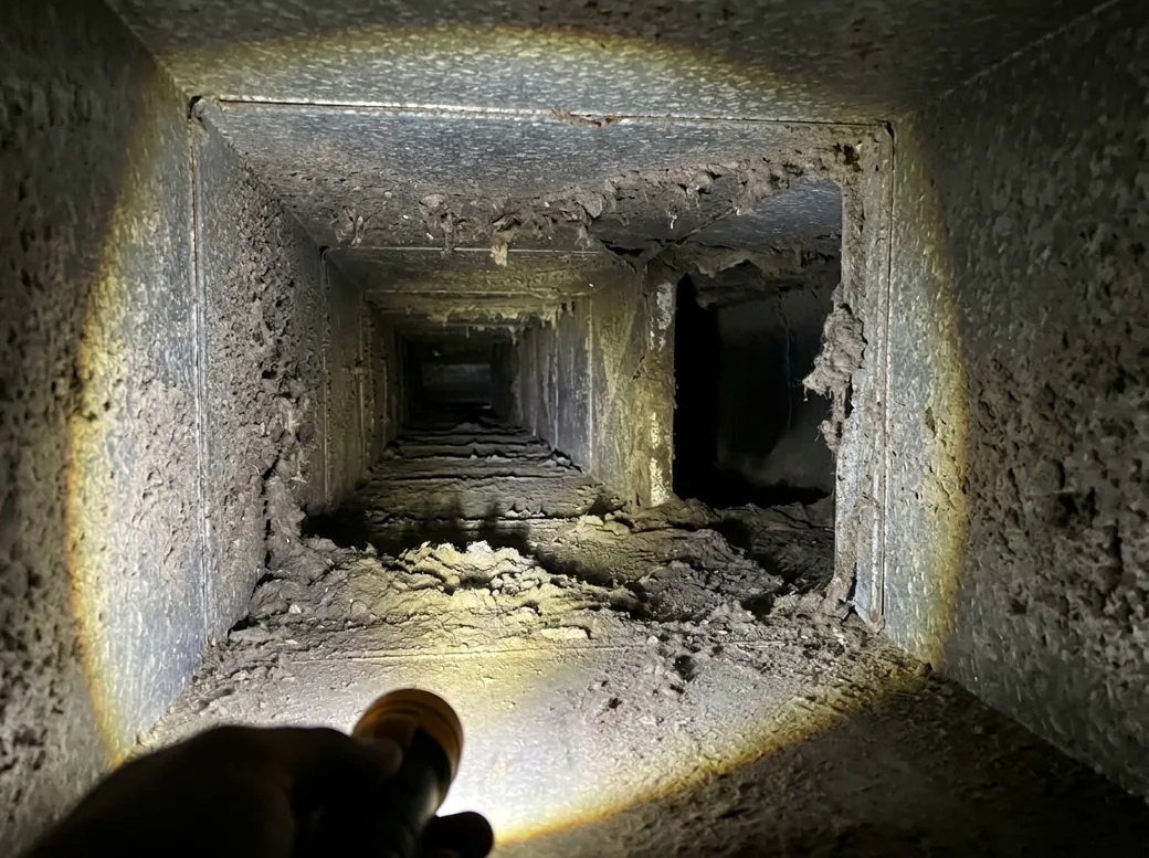 Air duct before cleaning, coated in dust